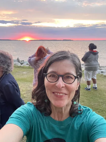Jennifer in the foreground of Teaching Artists before a sunset on Chesapeake Bay.
