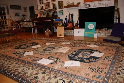 Materials arranged in a circle for group reflection and discussion at a TAMA retreat, with creative tools and artwork visible throughout the room.